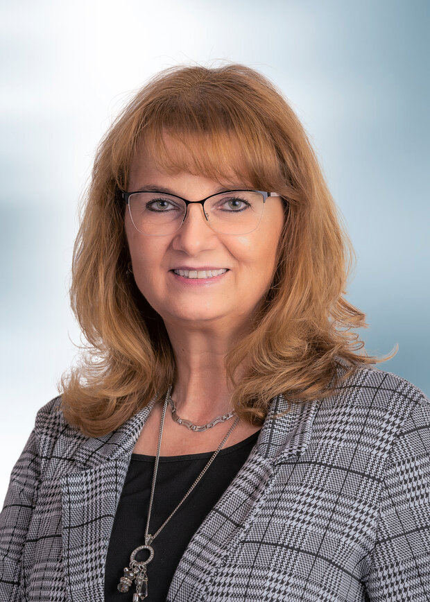 Martina Fischer, Technik, hat dunkelblonde schulterlange Haare und trägt eine Brille, dazu ein schwarzer Shirt mit einem karierten Blazer.