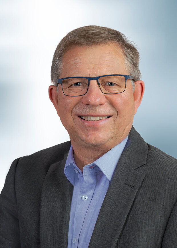 Thomas Stietz, Logistik, hat graue Haare, trägt eine Brille und ein hellblaues Hemd mit grauem Anzug.