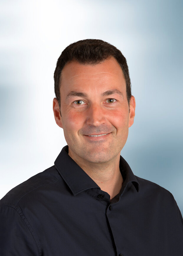 Christian Krause, Instandhaltung, hat dunkelbraune Haare und trägt ein dunkelblaues Hemd.