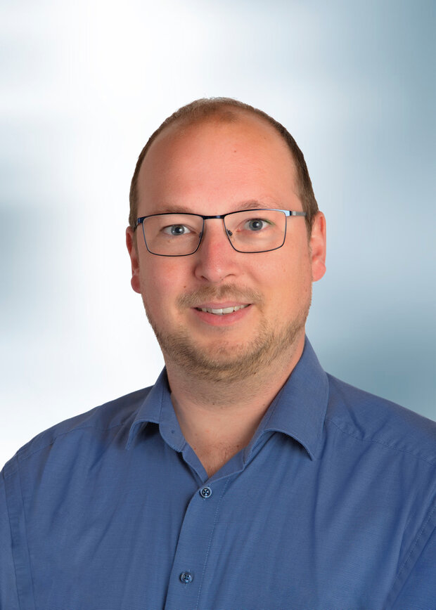 Christoph Michels, Instandhaltung, hat kurze dunkelblonde Haare, trägt eine Brille und ein blaues Hemd.