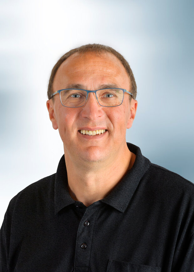 Joern Fischer, Instandhaltung, hat kurze dunkelblonde Haare und trägt ein schwarzes Polo-Shirt.