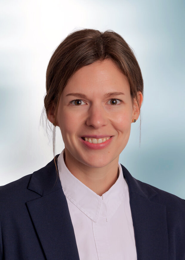 Josefin Lehra, Vetrieb Innendienst, hat braune Haare und einen Pferdeschwanz, trägt eine weiße Bluse mit blauem Jacket.