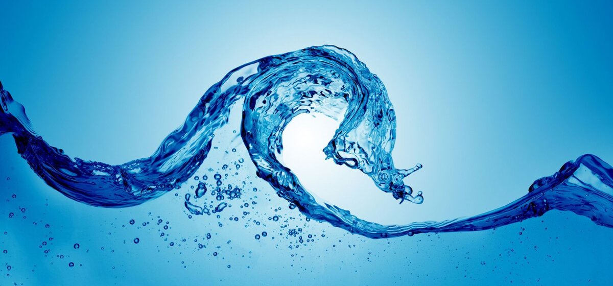 Wellenförmige Wasserbewegung mit Luftblasen vor blauem Hintergrund.